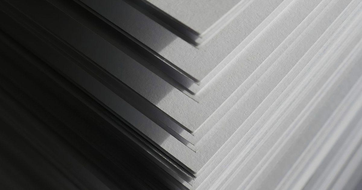 Corner of a tall stack of white paper sheets in soft side light